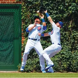  ?? (Reuters) ?? CHICAGO CUBS outfielder Ian Happ (right) collides with teammate Kyle Schwarber fielding a pop fly in the second inning of the Cubs’ 6-1 home victory over the Pittsburgh Pirates on Friday night at Wrigley Field.