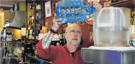  ?? EFE ?? Un camarero rellena una máquina de su bar con agua embotellad­a