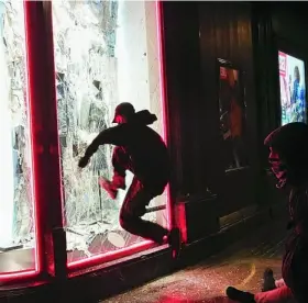  ?? EFE ?? Unos jóvenes destrozan el escaparate de una de las tiendas de Paseo de Gracia