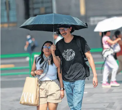  ?? HENRY ROMERO • REUTERS ?? People cover themselves with umbrellas as they walk past the Palacio de Bellas Artes (Palace of Fine Arts) during high temperatur­es, in Mexico City, Mexico May 9, 2024.