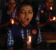  ?? AP/AJIT SOLANKI ?? Students at a school in Ahmadabad, India, hold candles and pray Monday for the boys and soccer coach who have been trapped in a cave in Mae Sai, Thailand.