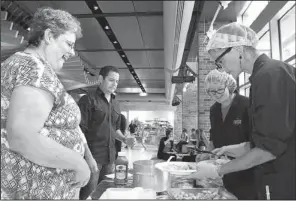  ??  ?? Susan Heffington and Eddie Morin wait apprehensi­vely for their “school lunch”
served up by lunch ladies Samantha Sauer and Lennie Dusek.