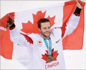  ?? The Canadian Press ?? Canadian defenceman Cody Goloubef carries the flag after Canada’s team of non-NHLers won bronze at the 2018 Olympic Winter Games, in Pyeongchan­g, South Korea. It looks NHL players will return to the games in 2022.