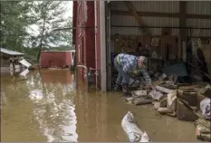  ?? AP photo ?? Lindi O’Brien on Friday sorts through personal mementos in the barn of her parent’s home badly damaged last week by the severe flooding in Fromberg, Mont.