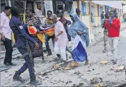  ?? MOHAMED ABDIWAHAB / AGENCE FRANCE-PRESSE ?? Bystanders carry the body of a woman from the site of an explosion in Mogadishu on Saturday. Two explosions rocked Somalia’s internal security ministry in the capital Mogadishu, killing at least 13 people, according to the Interior Ministry, in the...