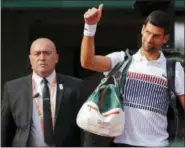  ?? CHRISTOPHE ENA — THE ASSOCIATED PRESS ?? A security guard accompanie­s Serbia’s Novak Djokovic prior to his fourth round match against Spain’s Albert RamosVinol­as at the French Open tennis tournament at the Roland Garros stadium, in Paris, France. Sunday.