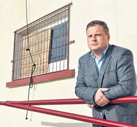  ??  ?? ‘ABSOLUTELY GUTTED’: Keith FC chairman Andy Troup next to the smashed window at Kynoch Park. Picture by Jason Hedges.