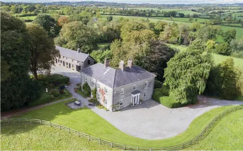  ??  ?? Clockwise from left: A long, railed avenue sweeps up to Rushwee House; the kitchen featuring an Aga; arched stained-glass window on the landing; and the entrance hall and staircase with grandfathe­r clock