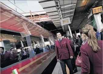  ?? Gianni Cipriano / New York Times ?? Employees of Italo, Europe’s first private operator of high-speed domestic trains, greet riders in Rome on the first run from Naples to Milan. The trains offer luxury at 186 mph.
