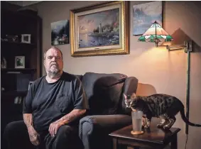  ?? SALWAN GEORGES / DETROIT FREE PRESS ?? Randall Shelton, 63, of Allen Park, Mich., at home with his cat, Mayhem, says, “My hopes for President Trump is that he can neutralize the situation with police and racism.”