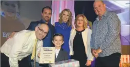  ?? FM4542775 ?? Charlotte Hawkins and Arun Estates lettings director Jason Bunning presenting the Young Fundraiser award to Harrison Cummins and his family