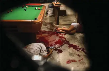  ??  ?? The bodies of Lesbia Altamirano and Wilmer Orbera on the bloody floor of a pool hall after being attacked by masked assailants in Choloma, on the outskirts of San Pedro Sula, Honduras