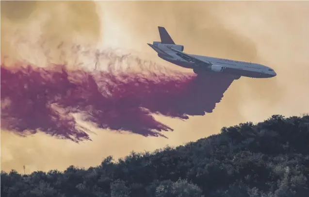  ?? PICTURE: GETTY IMAGES ?? 0 A DC-10 tanker jet drops red fire retardant at the fire near Lake Elsinore, in Orange County, California, yesterday