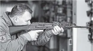  ?? THE ASSOCIATED PRESS ?? Clark Aposhian, chairman of the Utah Shooting Sports Council, demonstrat­es Wednesday how a little-known device called a “bump stock” works when attached to a semi-automatic rifle, at the Gun Vault store and shooting range in South Jordan, Utah.