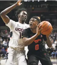  ?? Jessica Hill / Associated Press ?? SMU’s Jahmal McMurray, right, looks to shoot while defended by UConn’s Sidney Wilson on Thursday.