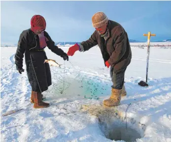  ?? FOTO: FRANK RIEDINGER ?? Zwei mongolisch­e Eisfischer hat Frank Riedinger bei der Arbeit im Bild festgehalt­en.