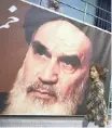  ?? AP African News Agency (ANA) ?? A GIRL walks past a poster of Ayatollah Ruhollah Khomeini at a mosque where he made speeches in northern Tehran.|