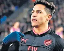  ??  ?? On the money: Alexis Sanchez strikes Arsenal’s second goal last night (right) and then is left to wonder why he is having to celebrate on his own (left)