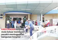  ??  ?? KAKITANGAN hospital mula keluar membawa pesakit meninggalk­an bangunan hospital