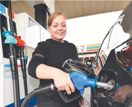  ?? Picture: TONY GOUGH ?? GOING FOR A SONG: Erin Ygarza fills up at a 7-Eleven service station in Melbourne. A potential oil price war between Russia and Saudi Arabia could see fuel prices at the bowser plummet.