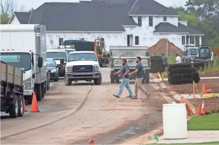  ?? MARK HOFFMAN/MILWAUKEE JOURNAL SENTINEL ?? Traffic is slowed as hordes of subcontrac­tors are busy working Aug. 6 in a new housing developmen­t on Century Farm Lane in Pewaukee.