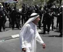  ?? Ahmad Gharabli/AFP ?? Palestino passa por militares israelense­s em Jerusalém