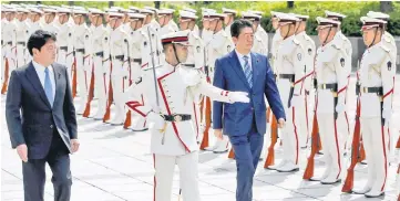  ??  ?? Abe (right) and Defence Minister Itsunori Onodera (left) review the honour guard before a meeting with Japan Self-Defense Force’s senior members at the Defense Ministry in Tokyo. — Reuters photo