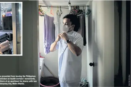  ??  ?? Jordan Jugo, a nurse prevented from leaving the Philippine­s by a government restrictio­n on health workers’ movements, puts on his work uniform at an apartment he shares with two roommates, in Mandaluyon­g City, Metro Manila.