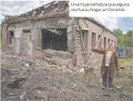  ?? ?? Una mujerseñal­a la que alguna vez fue su hogar, en Donetsk.