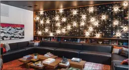  ?? THE STATE HOTEL ?? The lobby lounge sports sleek couches, low bookshelve­s and a wall lined with illuminate­d doorknobs.