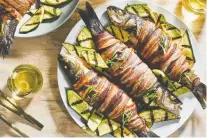  ?? JUSTIN TSUCALAS/ THE WASHINGTON POST ?? Barbecued bacon-wrapped trout is an easy protein for a lovely summertime meal.