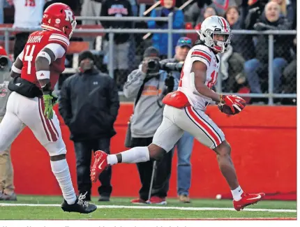  ??  ?? Ohio State wide receiver K.J. Hill scores a touchdown in front of Rutgers defensive back Tre Avery.