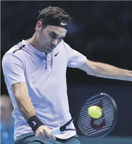  ?? GLYN KIRK/GETTY IMAGES ?? Roger Federer returns against Alexander Zverev during their round robin match at the ATP Finals on Tuesday at the O2 Arena in London. Federer won 7-6 (6), 5-7, 6-1, securing a spot in the semifinals.