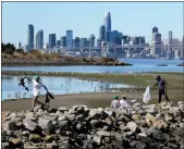  ?? RAY CHAVEZ — BAY AREA NEWS GROUP ?? Oliver Arnold, 12, left, of Oakland, and other volunteers take part in the annual Coastal Cleanup Day at Middle Harbor Shoreline Park Beach in Oakland, on Sept. 21, 2019.