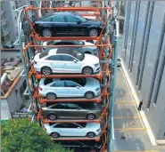  ?? ZHANG WENKUI / FOR CHINA DAILY ?? A 10-story vertical parking mechanism opens in Shenyang, Liaoning province, on Monday. Owned by a car dealership, parking is available to all for free.