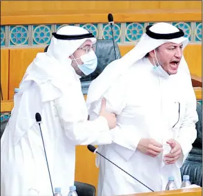  ?? Photo by Rizk Taufiq ?? MP Askar Al-Enezi (right), trying to prove a point during the Assembly session as MP Osama Al-Shaheen
tries to calm him down.