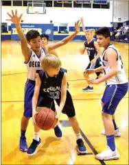  ?? Photo by Mike Eckels ?? The Cougar’s Tanner Barbour (center) tries to find an open teammate as Decatur’s Enrique Rubi (left) and Edgar Herrera (right) double-team him during the Decatur-Fayettevil­le New School junior high basketball matchup at Peterson Gym in Decatur on Nov. 6.