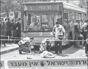  ??  ?? Israeli Zaka volunteers clean up blood stains at site where a 19-year-old Palestinia­n man stabbed a Jewish man in Jerusalem on Thursday.