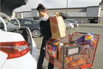  ?? Ben Margot / Associated Press ?? Instacart worker Saori Okawa loads groceries for delivery in San Leandro in July.