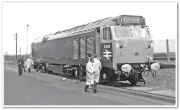  ?? TRIANGLE PUBLISHING (GERRY BENT). ?? Pure chance enabled the photograph­er to get this unique image of brand-new D433 crossing Wargrave Road as it leaves Vulcan Foundry to reach BR metals on July 4 1968. EE technician­s look on, like parents watching a child leaving home for the first time.