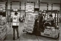  ?? Nathan Howard / Getty Images ?? Postal workers unload pallets of mail-in ballots this week at a USPS processing and distributi­on center in Portland, Ore.