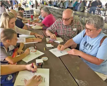  ?? NANCY DEGENNARO/USA TODAY NETWORK-TENNESSEE ?? Unitarian Universali­st Fellowship of Murfreesbo­ro members make button badges for the peaceful #Murfreesbo­roLoves counter-protest.