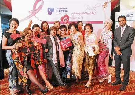  ??  ?? Wonder women: Breast cancer survivors striking a pose with Dr Gomez (in pink scarf) and hospital’s chief executive officer Anwar Anis (right) after the charity event.