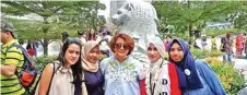  ?? DEVINA IVO/JAWA POS ?? TETAP HAPPY: Kelima anggota komunitas Huma Betang berkunjung ke Merlion Park kemarin.