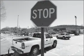  ?? NWA Democrat-Gazette/DAVID GOTTSCHALK ?? Traffic passes through stop signs Friday within the Fiesta Square parking lot in Fayettevil­le. The first concept maps for Fayettevil­le’s 71B corridor project were released Thursday. A roundabout is suggested at Fiesta Square, which would connect extensions of Appleby Road and Plainview Avenue.