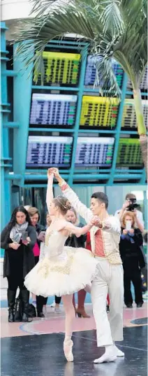  ?? JOE BURBANK/STAFF PHOTOGRAPH­ER ?? Travelers watch the Orlando Ballet’s Israel Zavaleta and Cara Bell dance to excerpts from “The Nutcracker” at Orlando Internatio­nal Airport. The holiday performanc­es, intended to help passengers cope with the stress of traveling, have been a tradition...