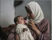  ?? ABDEL KAREEM HANA — THE ASSOCIATED PRESS ?? Rola Saqer feeds her baby, Massa Mohammad Zaqout, in her parents' home Thursday in Nuseirat, Gaza. Zaqout was born Oct. 7, the day the Israel-Hamas war erupted.