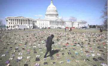  ??  ?? Seven thousand pairs of shoes, representi­ng the children killed by gun violence since the mass shooting at Sandy Hook Elementary School in 2012, are spread out on the lawn on the east side of the US Capitol in Washington, DC. — AFP photo