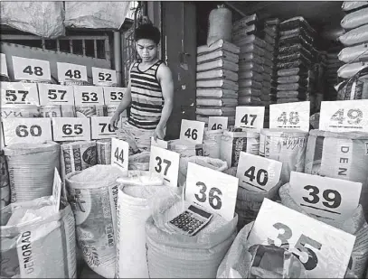  ?? BOY SANTOS ?? A vendor arranges price tags at a rice stall in Barangay Holy Spirit, Quezon City yesterday.