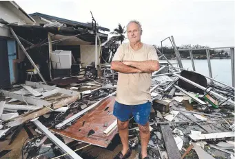  ??  ?? Airlie Shute Harbour Motel owner Dave Mcinnerney stands amid the wreckage after the building was destroyed by Cylone Debbie.